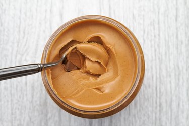 Peanut butter on spoon in jar