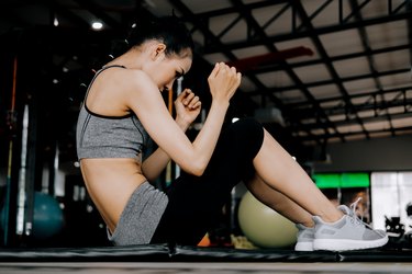 sport woman at fitness gym club doing sit up exercise for body and showing muscle bodybuilding, fitness concept, sport concept"n