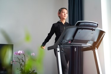 Asian woman exercising on treadmill home gym