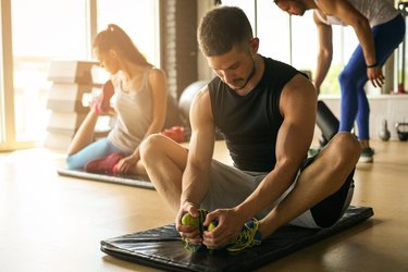 Group of people workout in healthy club. Young people stretching on floor.