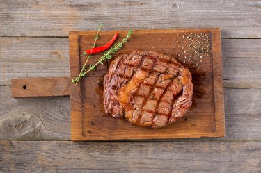 Rib eye steak on wooden board, closeup