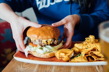 Woman holding hamburger stock photo