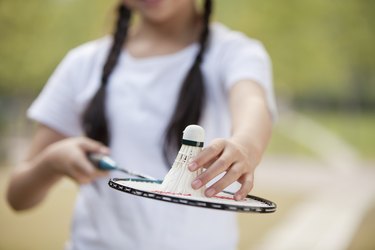 中国女孩拿着羽毛球拍和羽毛球