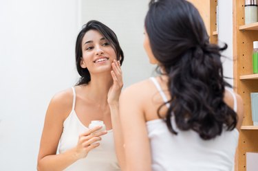 Woman applying moisturizer