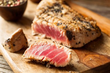 Perfectly seared niacin-rich tuna steak  on a wooden cutting board