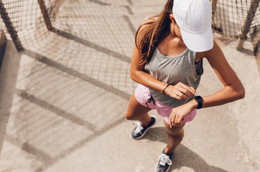 Female runner looking at smart watch heart rate monitor
