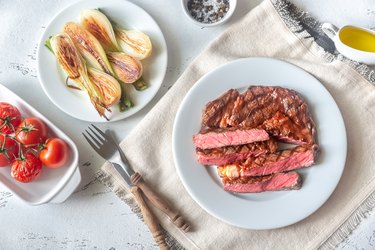 Grilled beef steak on plate with side of grilled veggies