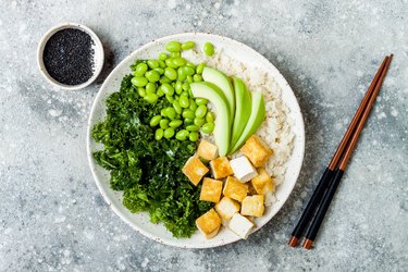 花椰菜佛碗饭与按摩羽衣甘蓝，豆腐，鳄梨和毛豆。素食碗