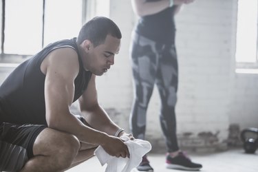 man resting from workout with towel