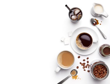 Different types of coffee and ingredients over white background with copy space