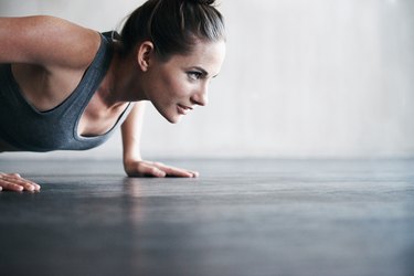 a close up of a young adult wearing a sports bra doing a push-up