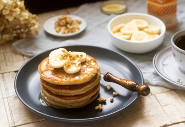 Pancakes with banana, nuts and honey, served with tea