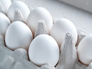 White fresh raw chicken eggs lie in a container for carrying eggs