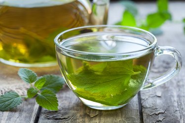 Fresh natural green peppermint tea with peppermint oil in glass cup