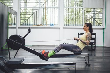 Athlete using rowing machine in gym