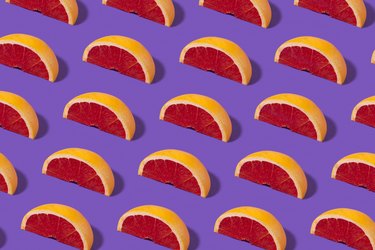 Slices of grapefruit in a pattern on a purple background