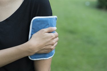 woman applying cold pack on her arm