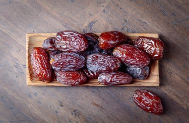 Juicy dates on wooden table .