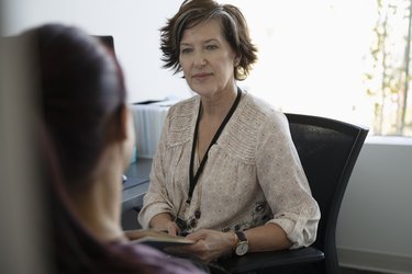 Attentive female doctor listening to patient in doctor s office