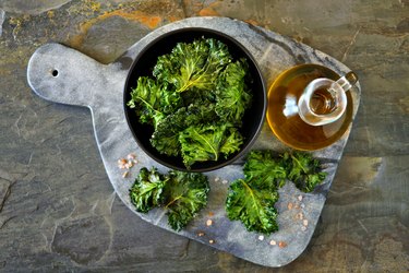 Platter of healthy kale chips, top view on slate