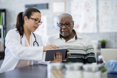 Doctor showing older man his test results on a tablet