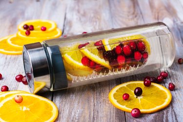 Infused water with cranberry and orange in a glass bottle