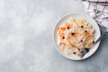 Homemade sauerkraut with carrots and cranberries in plate. Copy space