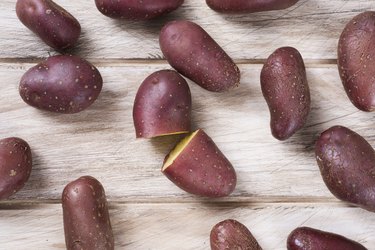 dark purple potatoes on wooden background