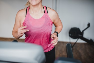 Young woman running on the treadmill in the gym