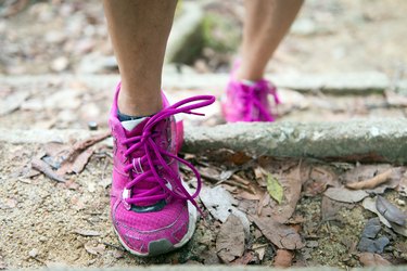 Hiking shoes on trail walking to lose weight in mountains