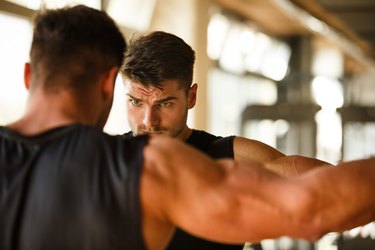 man flexing at the gym measuring muscle mass