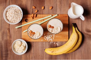 Ingredients and two portion of smoothies on the wooden table