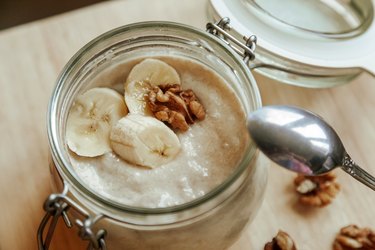 Classic homemade yogurt with slices of fruit. Banana with walnut. A wholesome morning breakfast.