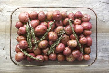 Small red potatoes with rosemary in a roasting dish ready for oven roasting