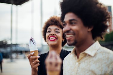 Beautiful girl trying her boyfriend's ice cream.