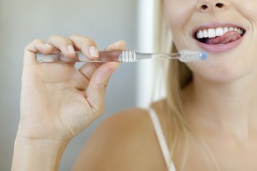 Woman brushing tongue and teeth