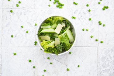 Directly above view of fresh salad in bowls by napkin and forks