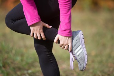 Warming up outdoors in the autumn, holding an ankle