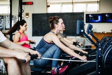 Fitness Team Using Rowing Machines Together