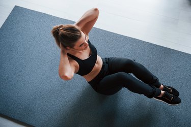 Nice blonde. Doing abs on the floor in the gym. Beautiful female fitness woman