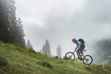 Person riding a mountain bike uphill in mountains.