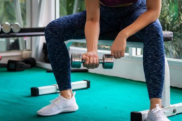 Beautiful athletic woman training in a gym, doing stretching