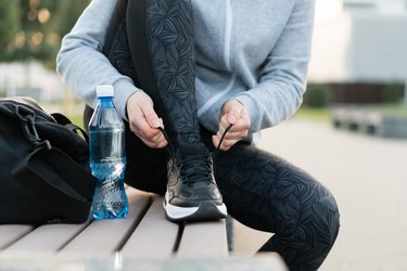 Shot of athletic woman tying she is shoelaces before a run.