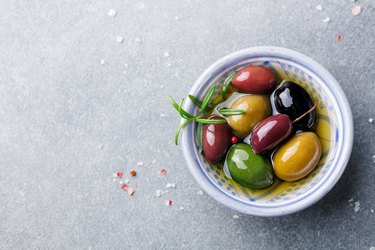 Olives assortment in bowl with oil.