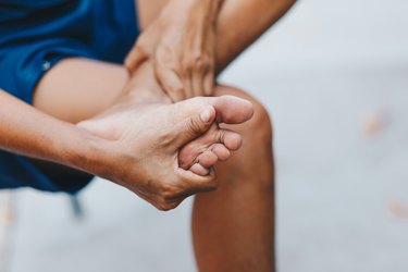 Closeup young woman feeling pain in her foot , Healthcare and medical concept