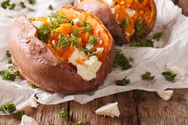 healthy food: baked sweet potato stuffed with cheese and parsley close-up. Horizontal
