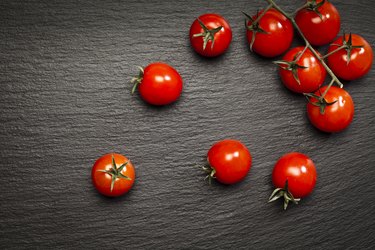 Tomatoes on black stone background