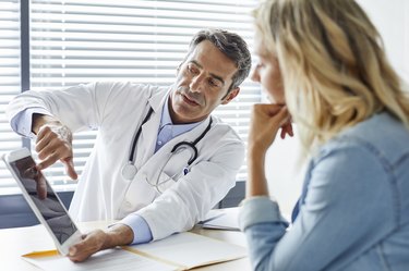 Doctor showing cholesterol levels to female patient