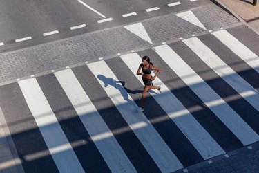 年轻女子在斑马交叉口跑步