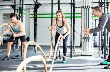 Fitness people working out with battle ropes